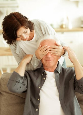 Téléchargez les photos : Surprise. Elderly woman covering the eyes of her husband at home. Lifestyle, love and family concept. - en image libre de droit
