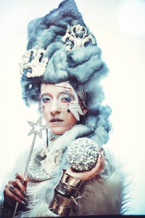 Foto de Retrato de Winter Beauty Woman con peluca plateada sosteniendo varita mágica y bola de Navidad. Hermosa modelo de moda femenina con estilo de pelo de nieve y maquillaje. Reina de invierno. Mujer de Navidad. - Imagen libre de derechos