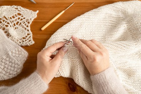 Foto de Senior manos femeninas tejiendo con lana blanca, vista superior, de cerca - Imagen libre de derechos