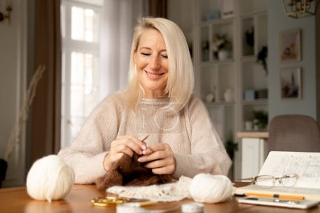 Téléchargez les photos : Femme Senior Adult Knitting Concept - Femme blonde âgée tenant des aiguilles à tricoter - en image libre de droit