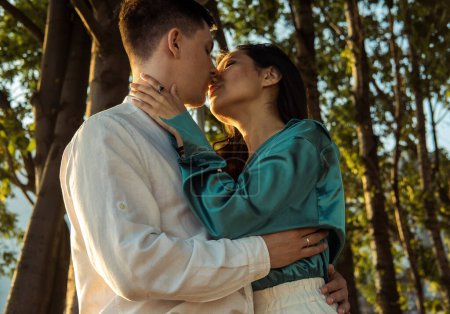 Téléchargez les photos : Jeune couple heureux amoureux de différentes nationalités embrassant et embrassant dans le parc.Femme asiatique et homme européen. Bonne heure d'été. - en image libre de droit
