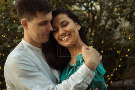 Photo for Young happy couple in love of different nationality hugging and kissing in the park.Asian woman and european man. Happy summer time. - Royalty Free Image