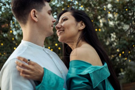 Foto de Joven pareja feliz enamorada de diferente nacionalidad abrazándose y besándose en el parque.Mujer asiática y hombre europeo. Feliz verano.. - Imagen libre de derechos