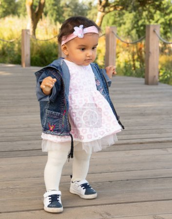 Téléchargez les photos : First steps of little girl in summer park. Lifestyle and childhood concept. - en image libre de droit