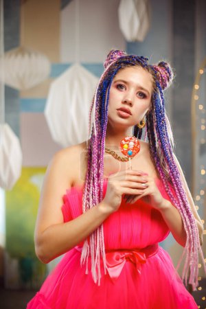Foto de Mujer atractiva joven con peinado dreadlocks y maquillaje creativo en estilo muñeca con dulces - Imagen libre de derechos