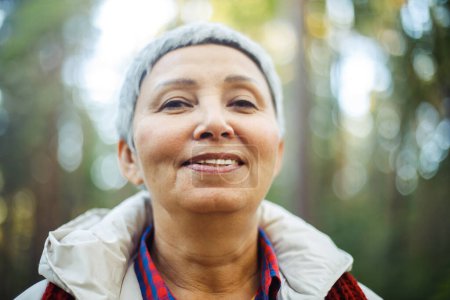 Foto de Retrato de una anciana asiática sonriente con el pelo gris corto en el parque. Día de otoño. - Imagen libre de derechos