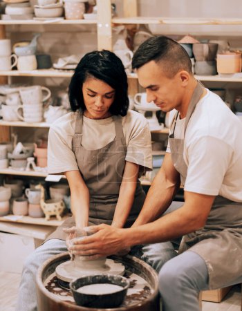 Foto de Pareja en el amor trabajando juntos en rueda de alfarero en taller de estudio de artesanía. Estilo de vida cocnept. - Imagen libre de derechos