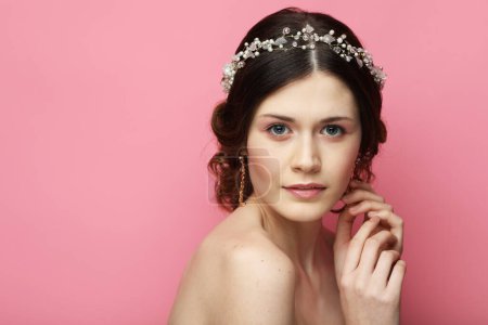 Foto de Mujer joven con diadema hermosa en el pelo, de cerca sobre fondo rosa. Hermosa novia. - Imagen libre de derechos