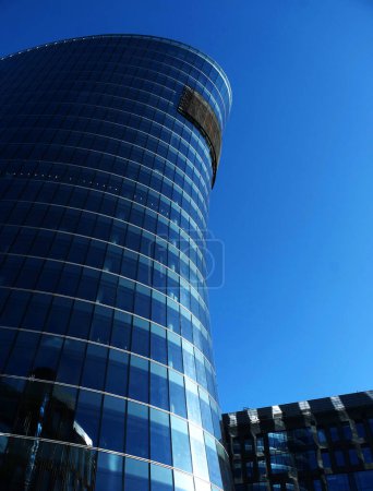 Téléchargez les photos : Immeuble de bureaux extérieur en été journée ensoleillée. Le ciel bleu s'était reflété dans le verre des fenêtres. Concept d'entreprise futuriste. - en image libre de droit
