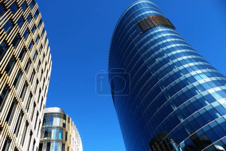 Téléchargez les photos : Immeuble de bureaux extérieur en été journée ensoleillée. Le ciel bleu s'était reflété dans le verre des fenêtres. Concept d'entreprise futuriste. - en image libre de droit