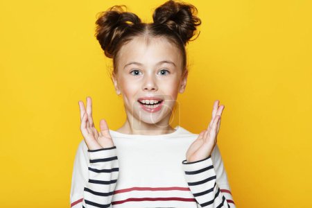 Photo for Adorable little girl with curly hairstyle posing on yellow background. Close up portrait. - Royalty Free Image