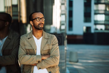 Photo for Confident stylish guy. Young man in glasses standing outside with arms crossed. Male portrait concept. - Royalty Free Image