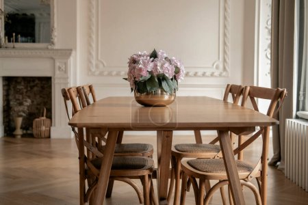 Téléchargez les photos : Table en bois avec chaises dans le salon. Intérieur moderne et élégant dans un style scandinave. Cosinesse. Mode de vie. - en image libre de droit
