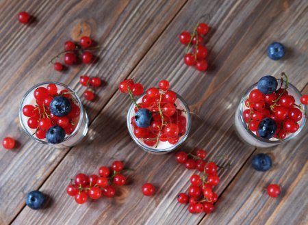 Photo for Good morning. Healthy breakfast - white yogurt with fresh berries in glass jar, on wooden background. Flat lay. - Royalty Free Image