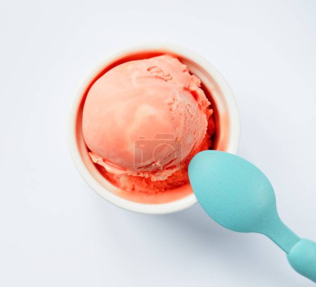Photo for Strawberry ice cream and blue spoon, top view over light grey backgound - Royalty Free Image