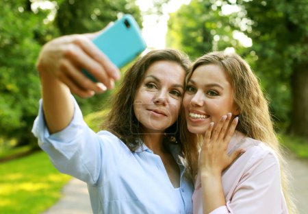 Photo for Happy senior woman and daughter taking selfie together, summer time - Royalty Free Image