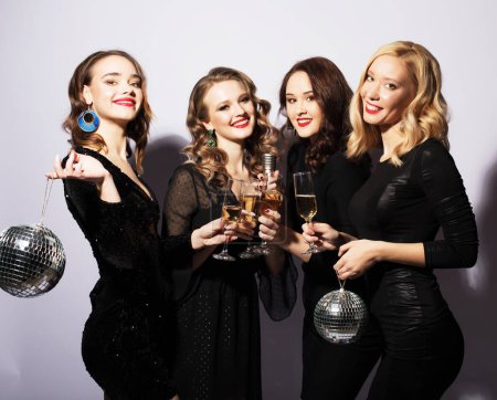 Photo for Four Party women in black dress with disco balls and wine over white background - Royalty Free Image