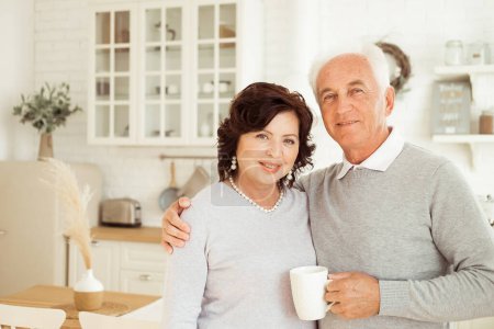 Téléchargez les photos : Happy old couple having coffee together on the kitchen - en image libre de droit