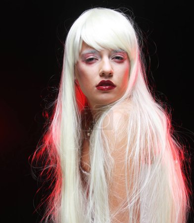 Foto de Hermosa joven con el pelo largo y blanco sobre fondo oscuro con smole. Moda, gente y concepto de fiesta. - Imagen libre de derechos