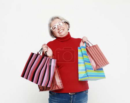 Photo for Lifestyle, shopping and old people concept: Happy elderly woman with shopping bags isolated on white background - Royalty Free Image