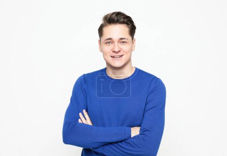 Photo for Young handsome man wearing blue sweater crossing hands and look at camera over white background - Royalty Free Image