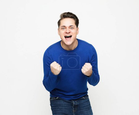 Foto de Lifestyle, people and emotion concept: Happy young handsome man gesturing and keeping mouth open over white background - Imagen libre de derechos