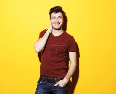 Téléchargez les photos : Lifestyle and people concept: Portrait of young smiling man standing against yellow background - en image libre de droit