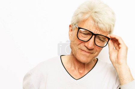 Foto de Cuidado de la salud, dolor, estrés, edad y el concepto de las personas - hombre de pelo gris guapo mayor que usa gafas que sufren de dolor de cabeza sobre fondo blanco - Imagen libre de derechos