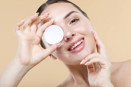 Photo for Young woman with daily morning skincare procedures, cleansing face skin with natural lotion tonic using cotton disc sponge pad. Beauty female with clean healthy skin, natural make up, spa concept - Royalty Free Image