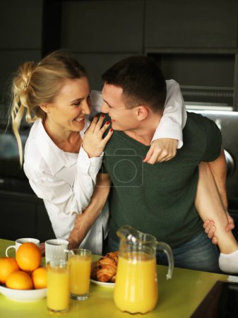 Téléchargez les photos : Mode de vie, amour, concept de famille et de personnes : Couple passionné embrassant et embrassant dans la cuisine. Jeune famille. - en image libre de droit