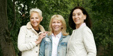 Téléchargez les photos : Three women friends in the park. Sixty-year-old ladies are dressed in casual clothes. - en image libre de droit