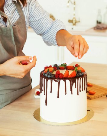 Téléchargez les photos : Mode de vie, personnes, cuisine et freelance concept : fermer les mains féminines décorer le gâteau avec du chocolat et des baies - en image libre de droit