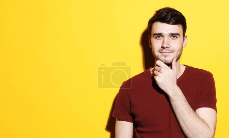 Foto de Retrato de un hombre guapo sonriendo sobre fondo amarillo. Un gay exitoso mirando la cámara. Concepto de estilo de vida y personas. - Imagen libre de derechos