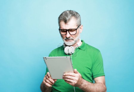 Photo for Photo of charming mature man dressed green shirt smiling typing modern device isolated blue color background - Royalty Free Image