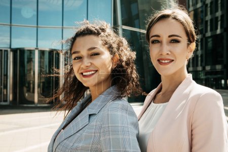 Photo for Lifestyle, business and people concept: Closeup portrait, two office workers standing together outdors near modern business building. Positive emotions. Summer day, - Royalty Free Image