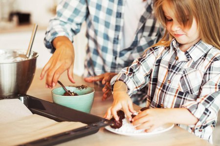 Téléchargez les photos : Mom with her 4 years old daughter are cooking in the kitchen to Mothers day, Family creativity, hobbies, joint activities with children. - en image libre de droit