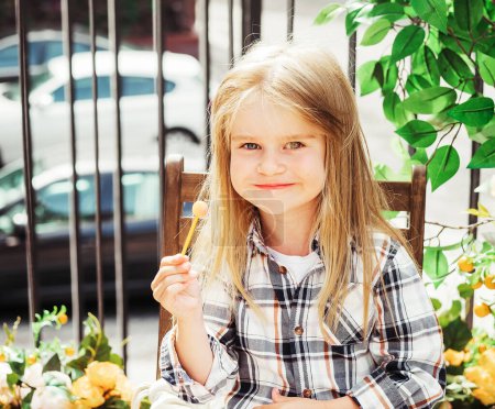 Photo for Adorable little blond girl child with a candy, outdoor portrait , summer time - Royalty Free Image