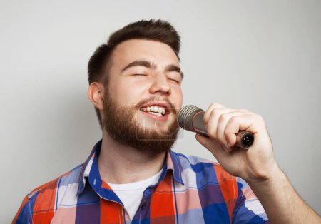 Téléchargez les photos : Style de vie et concept de personnes : jeune homme chantant avec microphone - en image libre de droit