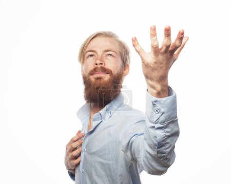 Téléchargez les photos : Emotion, people and body language concept: A young bearded man raises his hand up, calls for strength and good luck - en image libre de droit