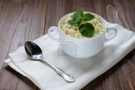 Téléchargez les photos : Bon petit déjeuner. Fromage cottage à la menthe dans un bol blanc sur une serviette blanche. - en image libre de droit
