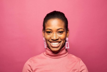 Téléchargez les photos : Portrait of young beautiful smiling dark skinned woman smiling and feel happy emotion isolated over pink background. - en image libre de droit