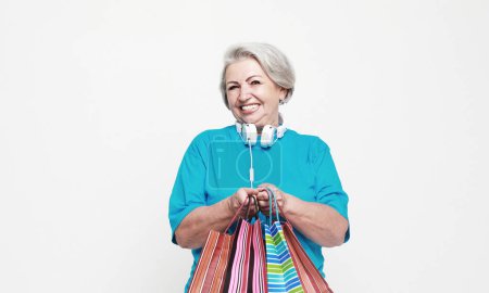 Téléchargez les photos : Lifestyle, shopping and old people concept: Happy mature woman with shopping bags isolated on white background - en image libre de droit
