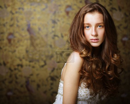 Téléchargez les photos : Mode, beauté et concept de personnes : Charmante jeune femme aux cheveux longs ondulés posant en regardant la caméra - en image libre de droit