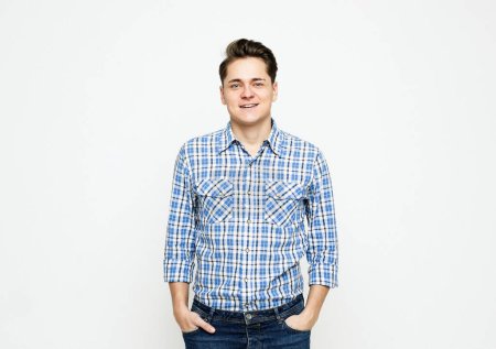 Photo for Waist-up shot of young man wearingblue shirt looking at camera over white background - Royalty Free Image
