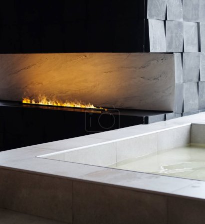 Téléchargez les photos : Luxurious bath next to artificial fire in a modern fireplace. Stylish chic interior. - en image libre de droit
