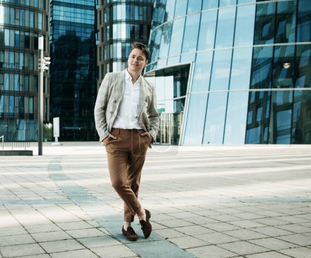 Foto de Negocios, personas y concepto de éxito: Hombre guapo en traje fashinable caminando cerca de la oficina moderna - Imagen libre de derechos