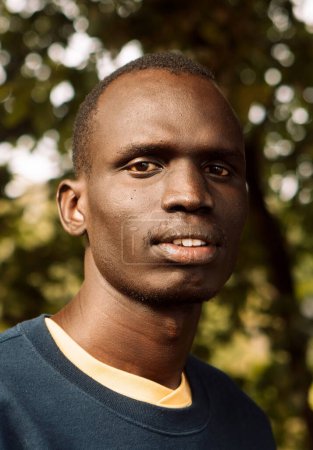 Téléchargez les photos : A young black man is walking in the park. Close-up portrait. - en image libre de droit