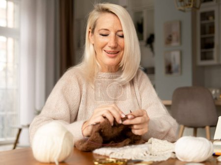 Téléchargez les photos : Woman Senior Adult Knitting Concept - Elderly blond woman holding knitting needles. Time for hobby. - en image libre de droit