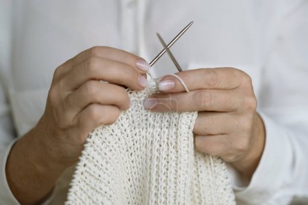 Téléchargez les photos : Woman's hands knitting white wool yarn pattern. Closeup horizontal photo. - en image libre de droit