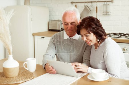 Téléchargez les photos : Senior couple using digital tablet at home, lifestyle and tehnology concept - en image libre de droit